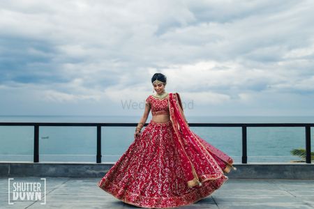 Photo of Red and gold bridal lehenga with sea facing view