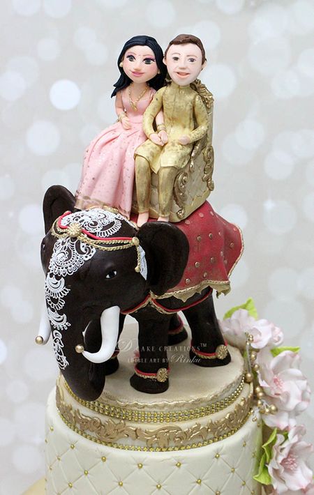 Photo of Destination wedding cake topper with couple on elephant