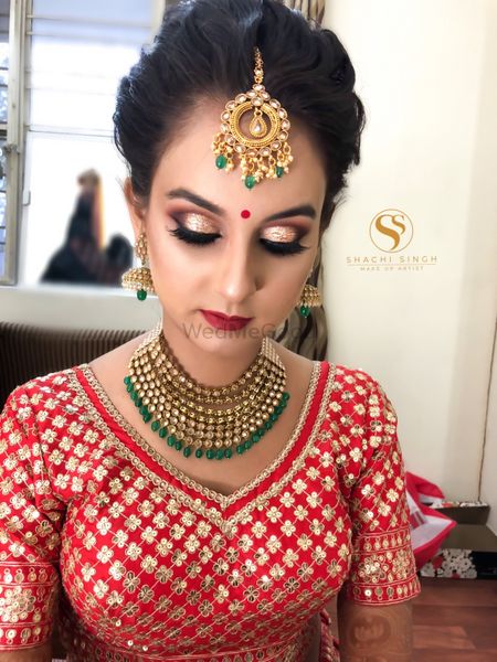 Pretty bride in red embroidered blouse with gold jewelry 