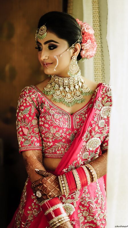 Bride in blush pink lehenga and exquisite jewellery.