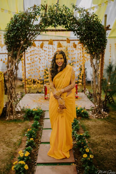 A minimal Haldi backdrop with bride in yellow saree! 
