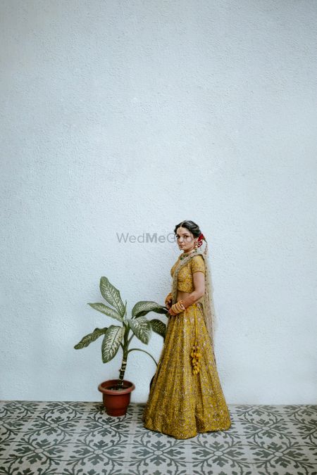 Bride dressed in a yellow lehenga.