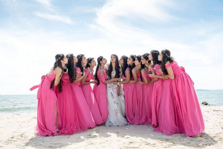 Photo of Coordinated bridesmaids in pink with bride on beach
