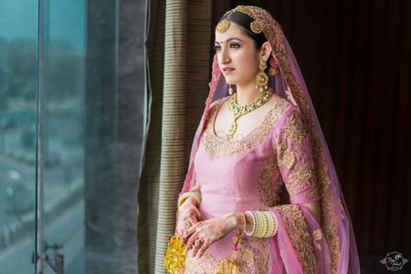 Bride in light pink Anarkali and yellow Chura 