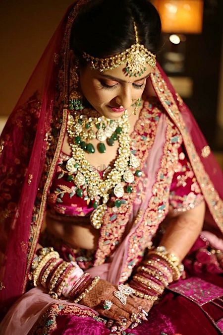 Contrasting layered bridal jewellery with red lehenga