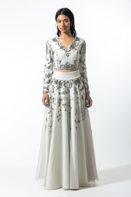 white engagement lehenga with belt and V neck full sleeved blouse