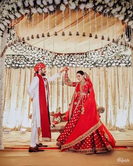 The bride is stunning red lehenga dancing with the groom 