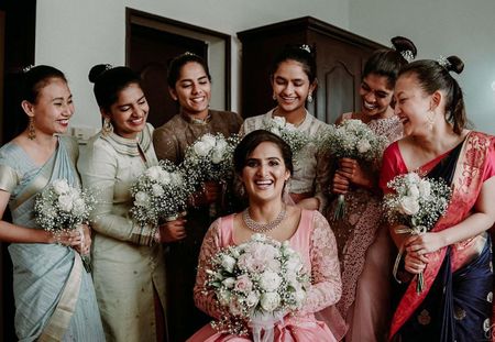Photo of Bride with her bridesmaids holding the bouquet.