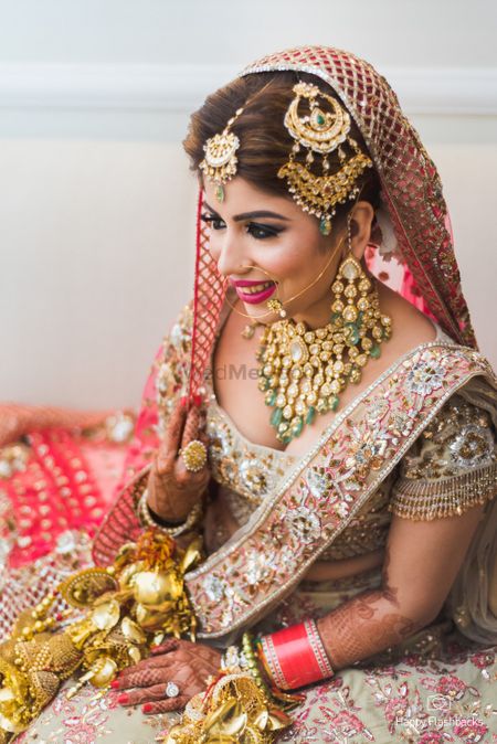 Photo of Bridal pose with heavy bridal jewellery and beautiful jhoomer