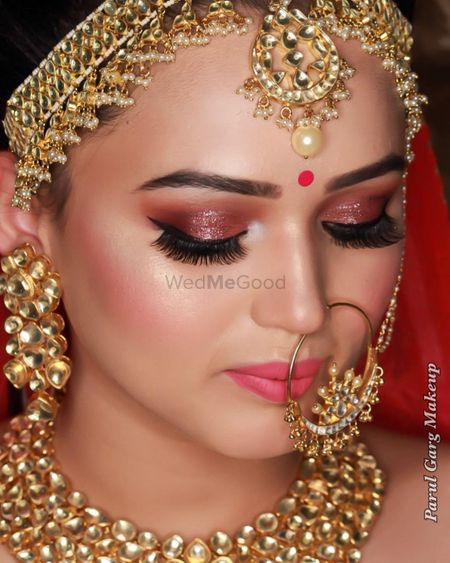Beautiful dewy skin makeup with extended eyelashes and peach gold shimmer eyes with a lovely highlight