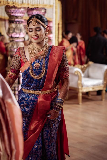 South Indian bride in a navy blue saree with red border.