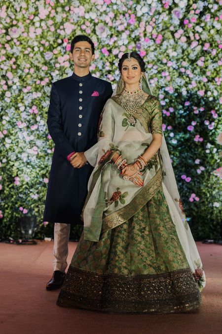 Photo of A bride in green lehenga with her groom