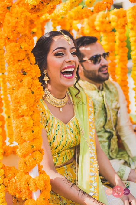 Photo of A bride smiling on her Haldi.