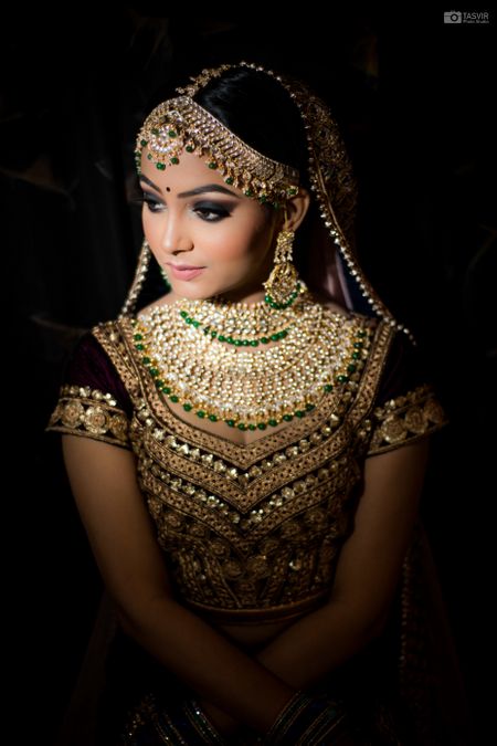Gorgeous maroon lehenga for wedding with dazzling kundan and green beads jewellery 