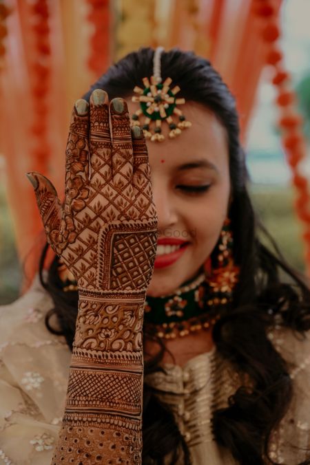Bride showing off her back hand mehndi design. 