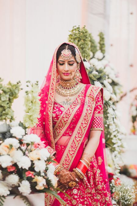 ShaadiWish - When it comes to contrasting your jewellery with your outfit,  it can go either way. But this bride surely nailed her gorgeous pink  lehengas with distinct pastel green jewellery pieces.