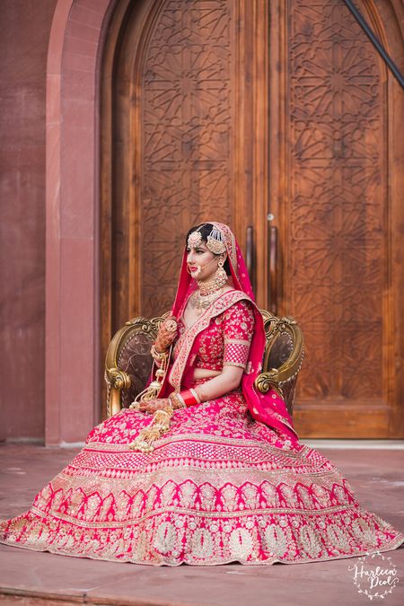 Regal bridal portrait pose in red lehenga 