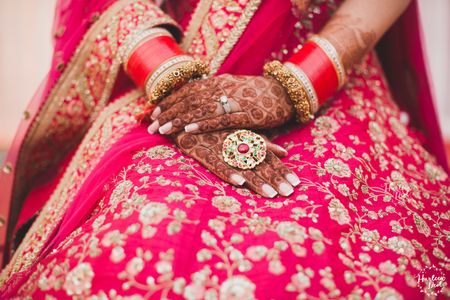 Photo of Bridal hands with cocktail ring with red stone