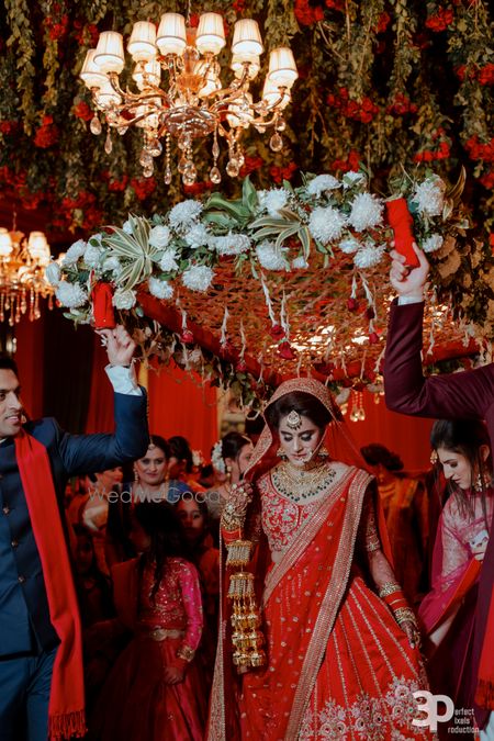 Bride walking in under phoolon ki chadar with white flowers 