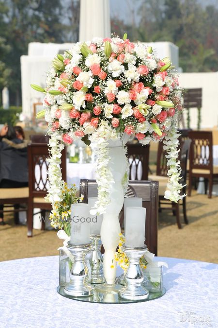 Photo of Floral table centerpiece with candle stands around