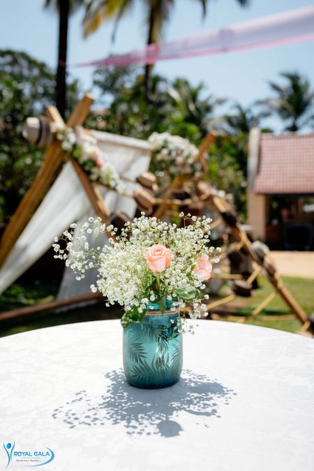 Mason jar filled with roses & baby's breath used as a centrepiece.