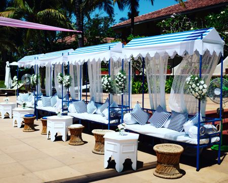 White and blue tent seating arrangement for guests.