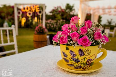 Photo of Tea cups with pink roses as table centerpiece