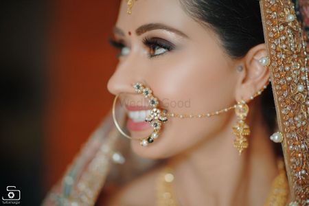A bridal nath with floral motifs and pearls.