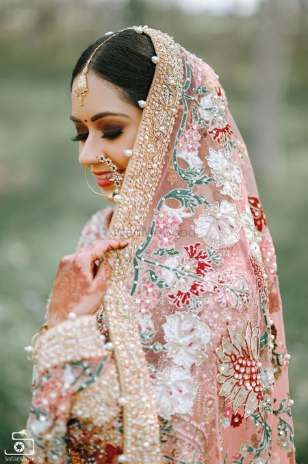 A close-up shot of a Sikh bride holding her dupatta. 