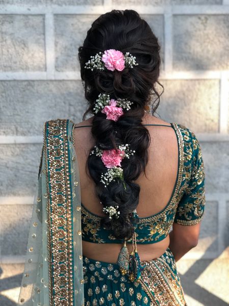 Photo of Braided hairdo with baby's breaths and pink carnations.