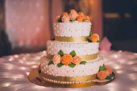 3 tiered orange white and gold wedding cake