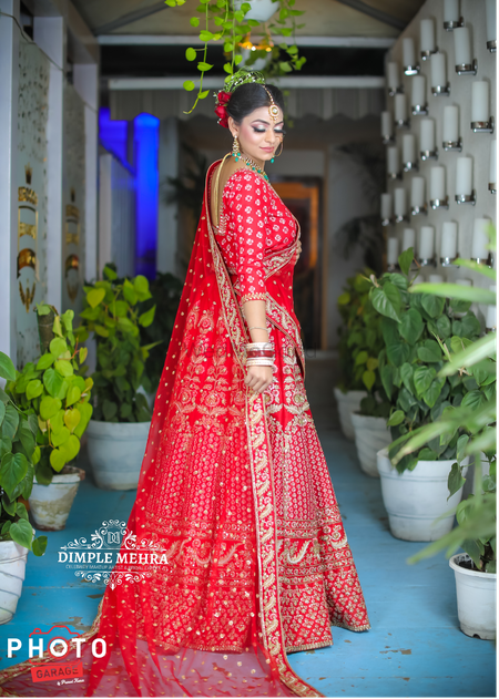 Gorgeous red lehenga and a bride with roses in the bridal bun 