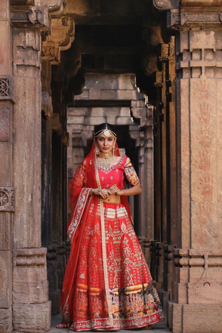 Photo of Red and gold bridal lehenga with contrasting border