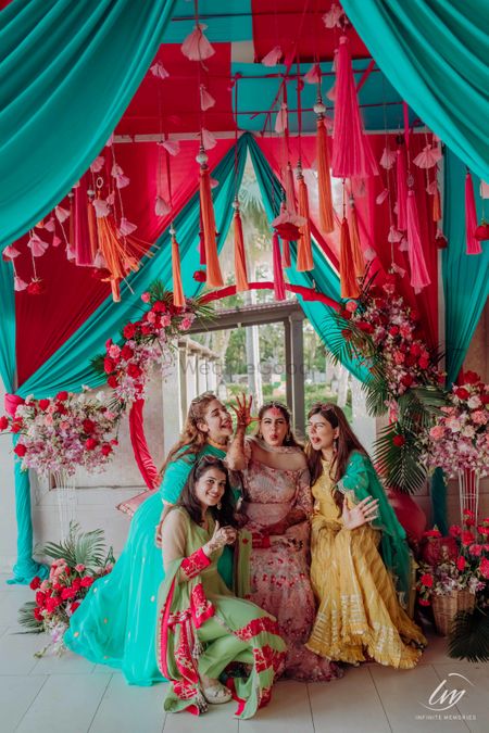 Photo of bride with bridesmaids on mehendi with tassel decor