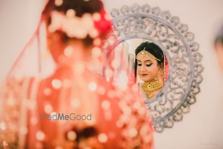 Bride looking into mirror shy portrait 