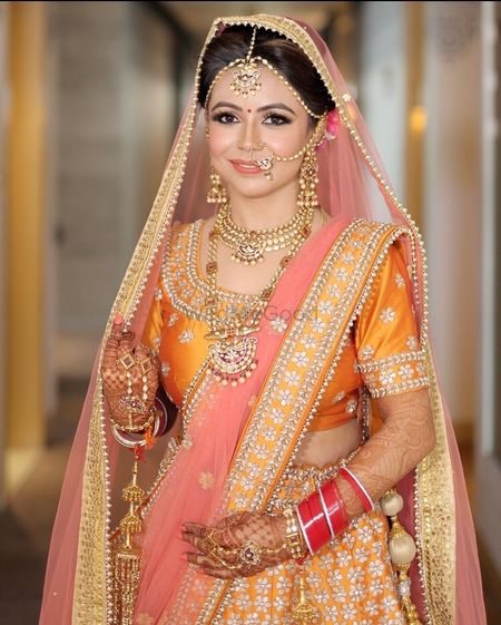 A bride in orange and pink lehenga 