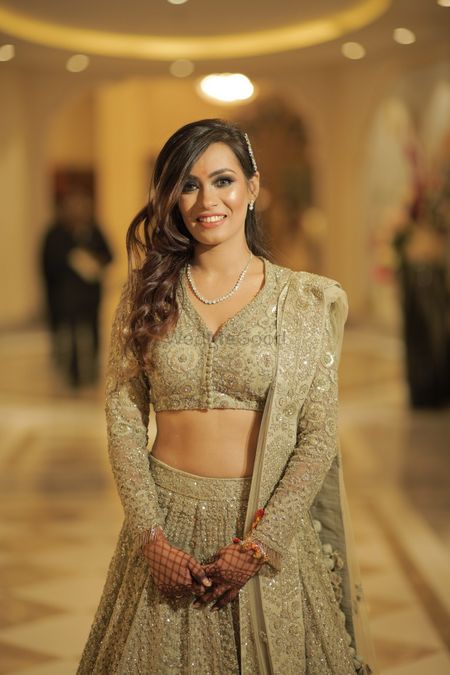 Photo of A happy bridal shot in a stunning gold lehenga and subtle makeup.