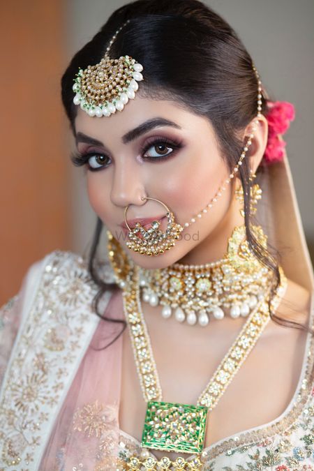 A bride in a white lehenga and subtle makeup for her wedding 