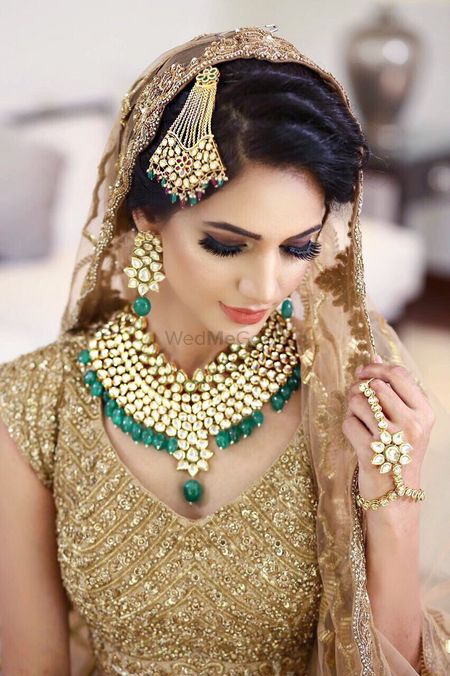 Contrasting bridal jewellery with green stones