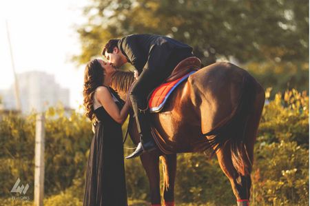 Couple kissing romantic pre-wedding shot with horse