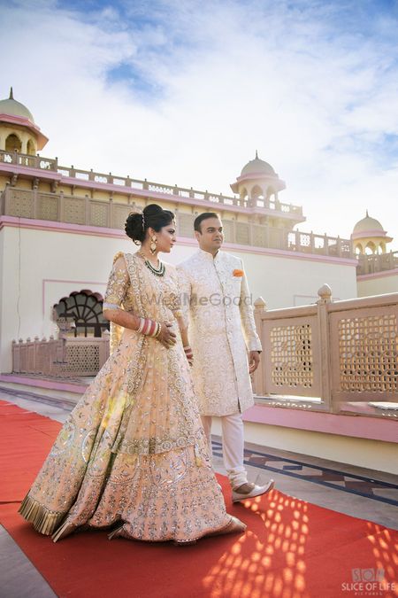 A bride and groom in coordinated ivory outfits