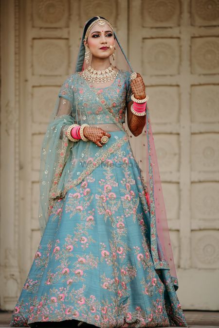 A bride in a blue lehenga with pink chooda 
