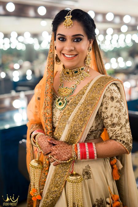 Orange and gold bridal look with orange kaleere and green jewellery