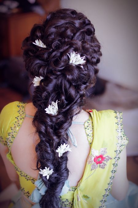 Twisty braid hairstyle with flowers for mehendi 