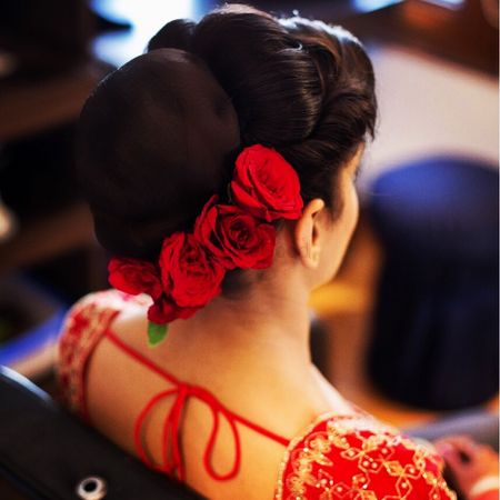 Bridal hairstyle with a bun and red roses