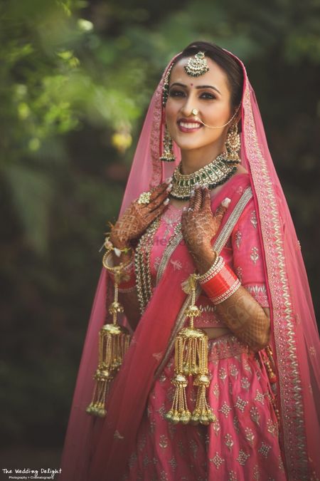 Sikh bride in bright pink bridal lehenga and kaleere 