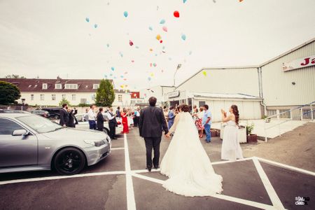 Photo of Guests releasing balloons on bride and groom entry