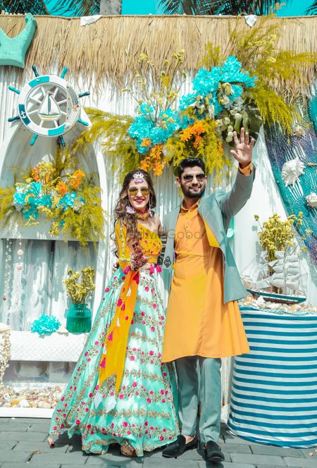 Matching bride and groom in mustard and teal outfits 