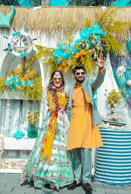 Matching bride and groom in mustard and teal outfits 