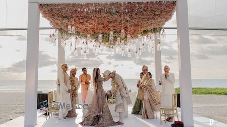 Photo of Destination wedding mandap shot with a gorgeous floral ceiling and hanging decor elements